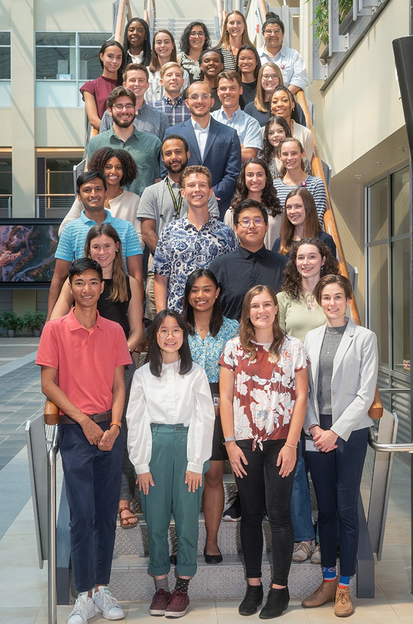 The 2021 undergraduates participating in the Department of Biomedical Engineering's summer research opportunities stand on the stairs in the atrium of BioTech Place