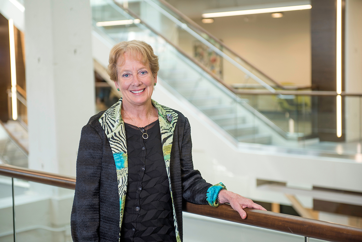 Dean of Wake Forest School of Medicine Julie Ann Freischlag, MD, FACS, FRCS, ED (Hon), DFSVS, smiles as she stands in the atrium of the Bowman Gray Medical Education Building