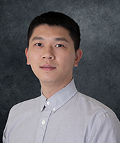 A young man in a dress shirt looking at the camera.