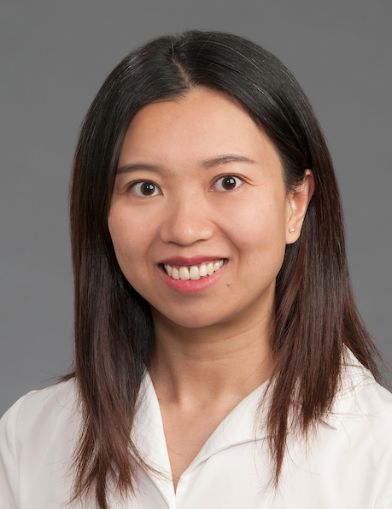 A young woman with black hair smiling at the camera.